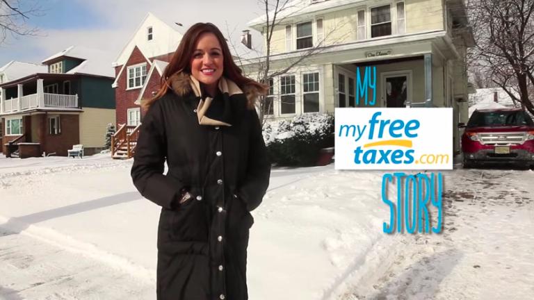 young woman in front of a house with my free taxes banner on the side